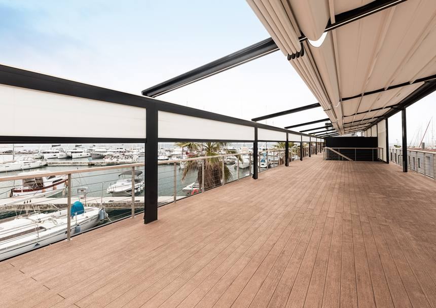 Pergola con copertura a telo scorrevole e chiusure screen su una terrazza affacciata sul porto