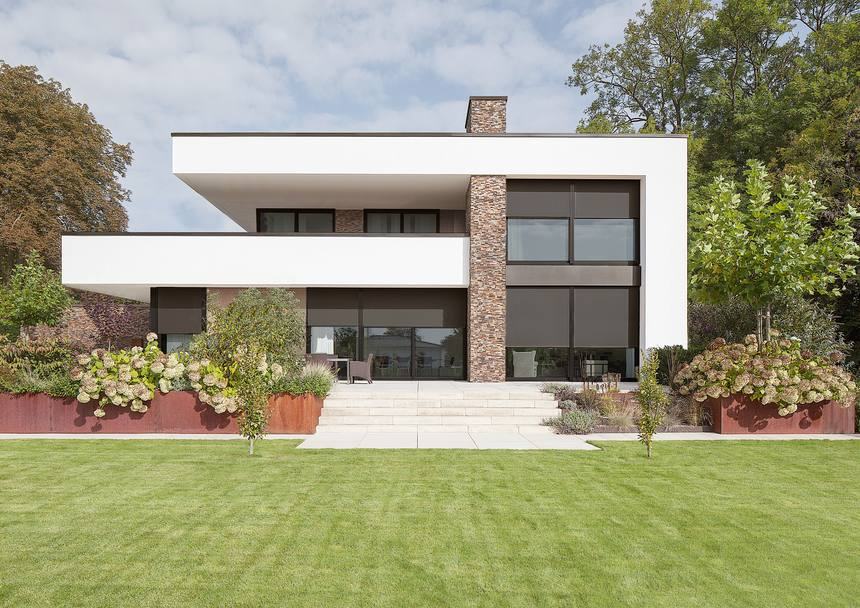 Villa contemporanea con tende screen ZIP calate sulle grandi vetrate