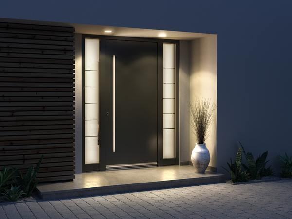 Portoncino d'ingresso antracite con vetrate laterali illuminate, vista notturna