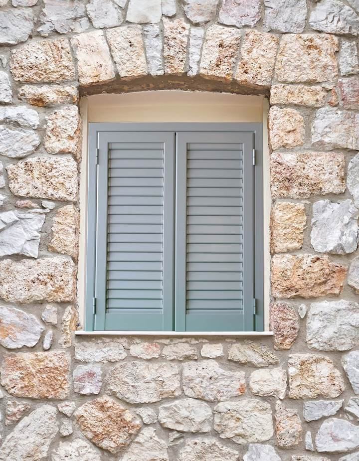 Persiana in alluminio a lamelle orientabili su una facciata in pietra